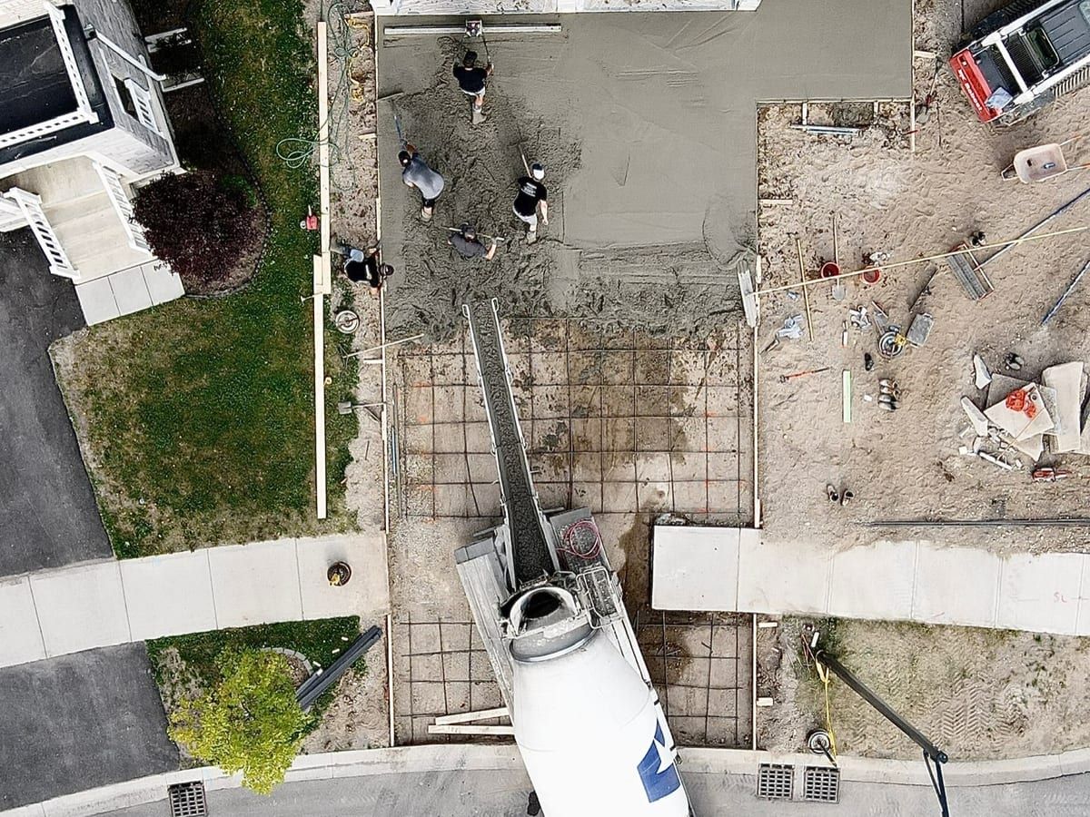 Drone view of the driveway pour in progress with the pump truck set up on the street