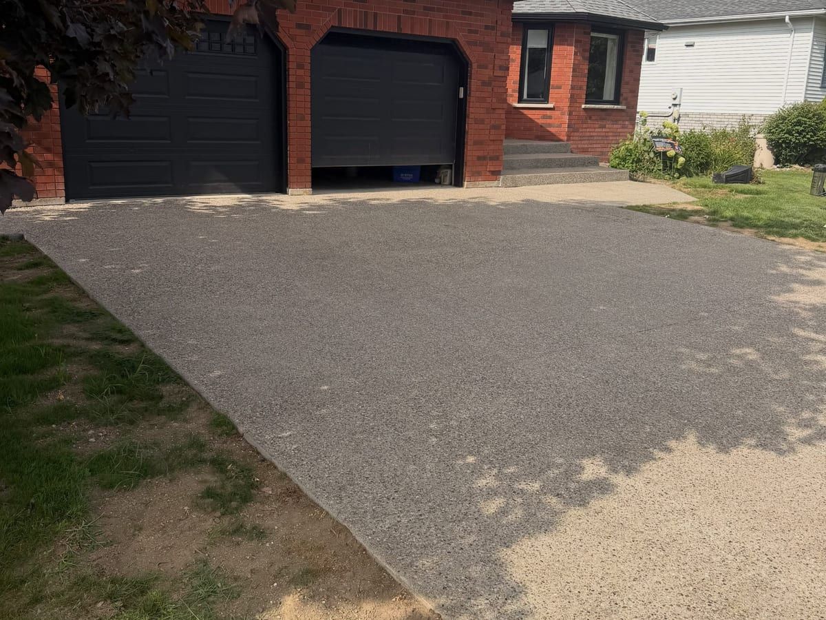 Finished exposed aggregate concrete driveway with warm integral colour in Brantford